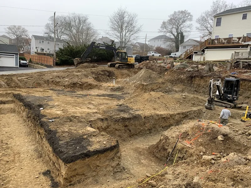 Deep excavation for a new foundation with an excavator working