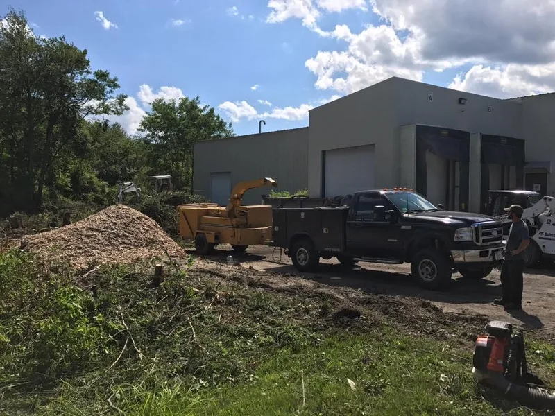 Brush chipper and pickup truck clearing a lot
