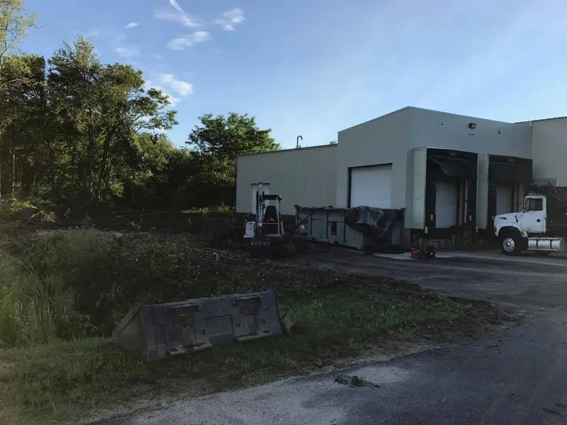 Industrial building with a dump truck and excavator on site