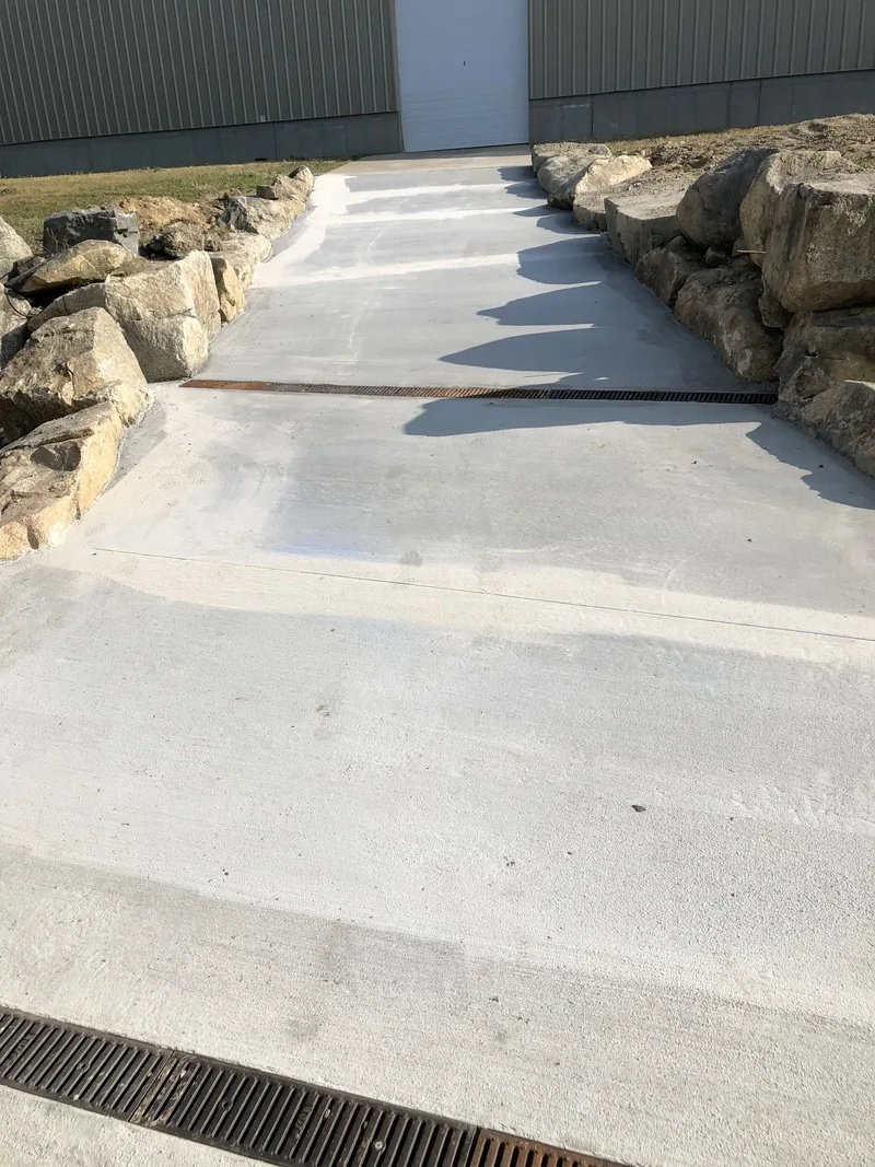 Poured concrete channel beside a stone retaining wall