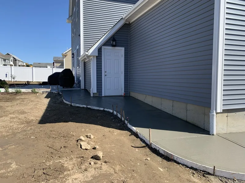 Curved concrete walkway edging along a home