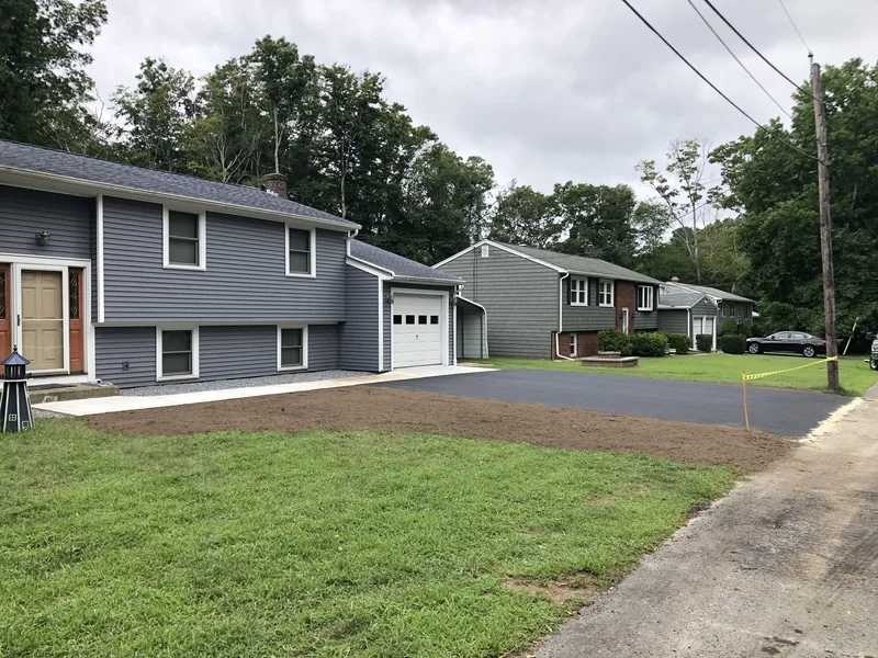 Fresh green lawn and new driveway at a split-level home
